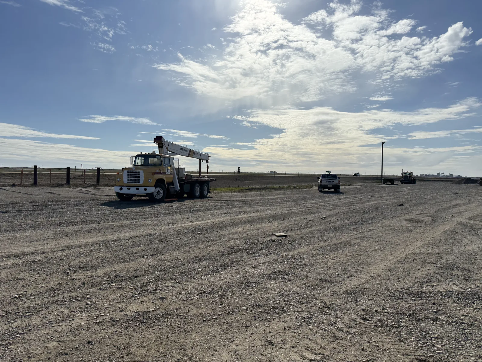 Open gravel pad and yard at Frontier with a boom truck under a big North Slope sky