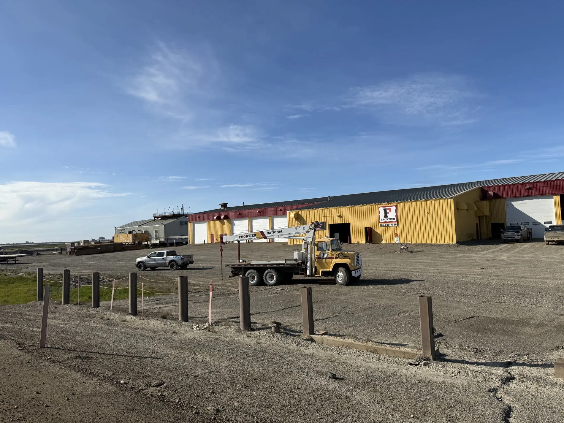The Frontier shop complex and gravel pad under a clear North Slope sky
