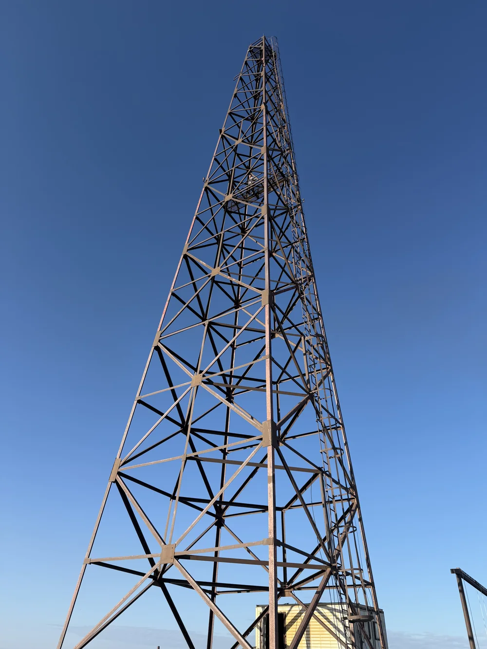 Standing steel lattice tower at Frontier against a deep blue North Slope sky